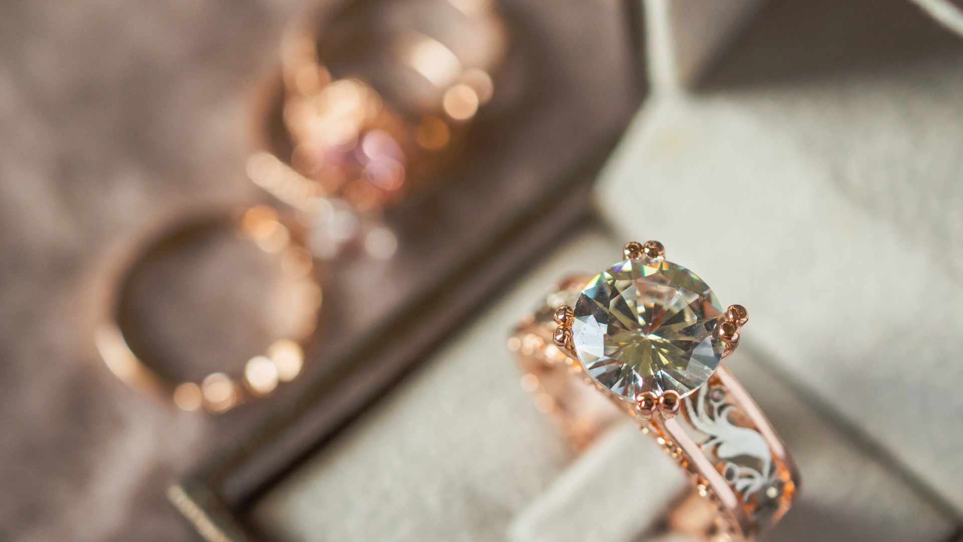Une bague en or rose avec un grand diamant rond dans une boite à bijoux